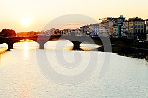 The Ponte Santa Trinita over Arno river at sunset, seen from Ponte Vecchio in Florence. .