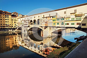 Ponte Vecchio is mirroring in the river Arno, Florence