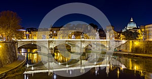 Ponte Vittorio Emanuele II and Tiber river by night, St. Peter basilica in the background, Rome, Italy.