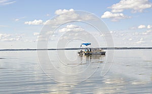 Pontoon boat coasting in a large body of water.