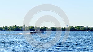 A pontoon boat speeds along on beautiful Lake Irving