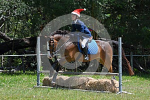 Pony rider jumping with Father Christmas hat