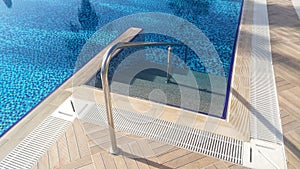 The pool and the areas near the pool are ceramic tiled. There are steps at the water entrances and metal handrails for safety. Sun