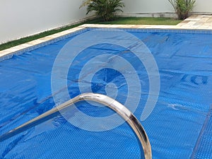 Pool in backyard with a thermal cover