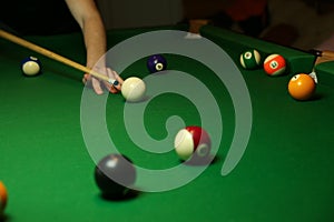 Pool balls and billiard cue on green billiard table