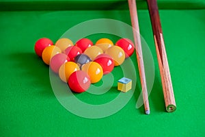Pool balls, chalk and cue on a table