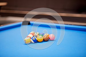 Pool balls set arranged as triangle on blue