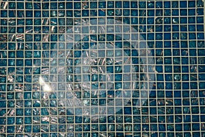 A pool with blue ceramic tiles and water ripple effect. Refection of Blue water in Swimming pool with Ripple. close-up