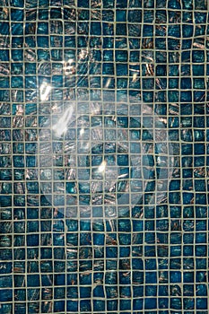 A pool with blue ceramic tiles and water ripple effect. Refection of Blue water in Swimming pool with Ripple. close-up