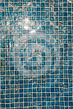 A pool with blue ceramic tiles and water ripple effect. Refection of Blue water in Swimming pool with Ripple. close-up