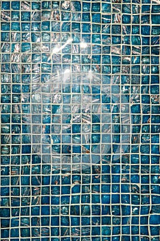 A pool with blue ceramic tiles and water ripple effect. Refection of Blue water in Swimming pool with Ripple. close-up