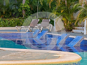 Pool with a blue tiled floor and a white wall