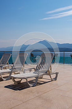 Pool chairs overlooking ocean, sunny day