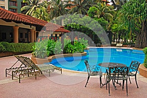 Pool of a Condominium with deckchair and table chair