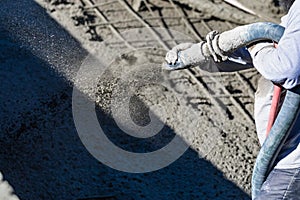 Pool Construction Worker Shooting Concrete, Shotcrete or Gunite Through Hose