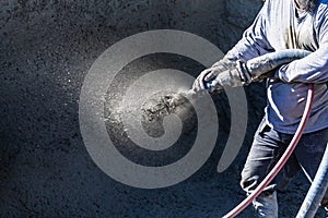 Pool Construction Worker Shooting Concrete, Shotcrete or Gunite Through Hose