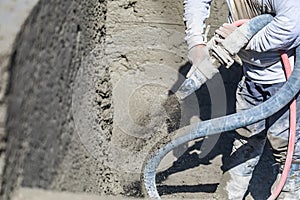 Pool Construction Worker Shooting Concrete, Shotcrete or Gunite Through Hose