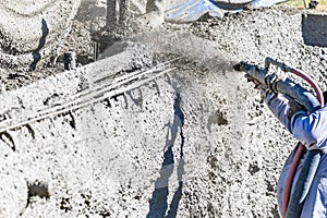 Pool Construction Worker Shooting Concrete, Shotcrete or Gunite Through Hose