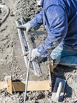 Pool Construction Worker Working With A Smoother Rod On Wet Concrete