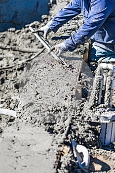 Pool Construction Worker Working With A Smoother Rod On Wet Concrete photo