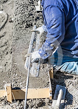 Pool Construction Worker Working With A Smoother Rod On Wet Concrete photo