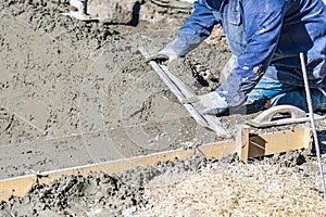 Pool Construction Worker Working With A Smoother Rod On Wet Concrete