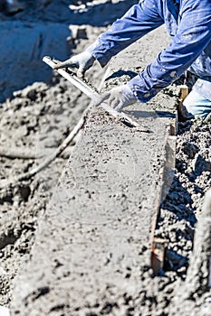 Pool Construction Worker Working With A Smoother Rod On Wet Concrete photo