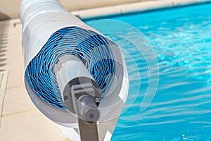 Pool cover on the edge of a pool during the summer