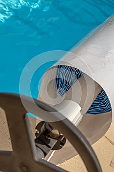 Pool cover on the edge of a pool during the summer