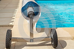 Pool cover on the edge of a pool during the summer