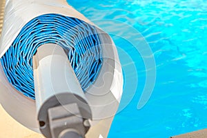 Pool cover on the edge of a pool during the summer