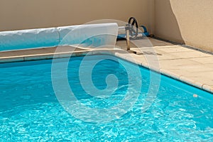Pool cover on the edge of a pool during the summer