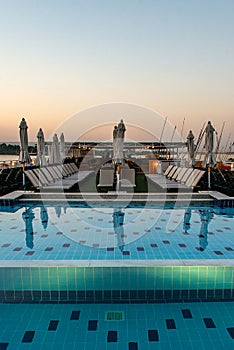 Pool deck and parasols of luxury boat cruise ship in egypt luxor during dawn sunset