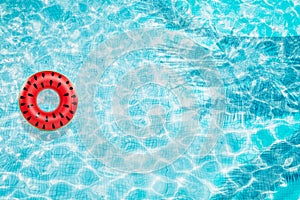 Pool float, ring floating in a refreshing blue swimming pool with palm tree leaf shadows in water
