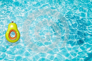 Pool float, ring floating in a refreshing blue swimming pool with palm tree leaf shadows in water