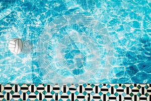 Pool float, ring floating in a refreshing blue swimming pool with palm tree leaf shadows in water
