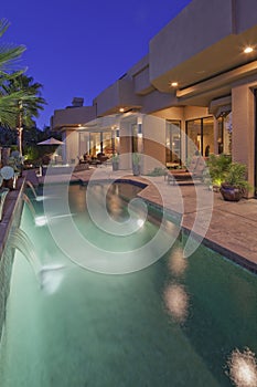 Pool with house exterior at dusk