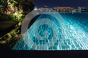 Pool at night with lush greenery and lighting for home design an