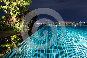 Pool at night with lush greenery and lighting for home design an