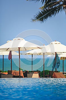 Pool and Ocean with beach chairs and umbrellas