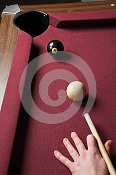 Pool player lining up billiard balls for winning shot