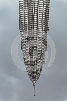 Pool reflected of bended Petronas twin towers in Kuala Lumpur, Malaysia