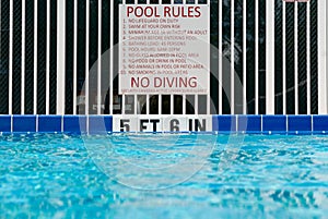 `Pool rules` sign posted at the deep end of a swimming pool