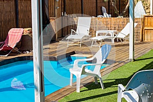 Pool side villa back yard space with white deck chair in summer sunny day time vacation season