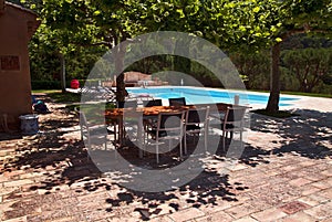 By the pool; Table and chairs in the shadow of Plane Trees