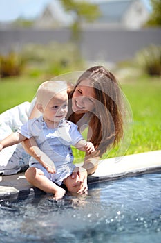 Pool, water and mom with baby in garden or child splash with legs for fun, game or experience. Happy kid, swimming and