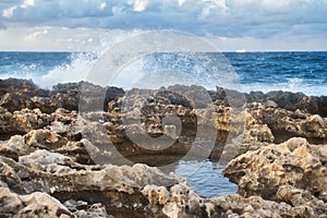 Pool of water in rocky shore on a beach in Qawra