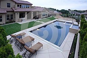 A pool with a waterfall in a luxury backyard