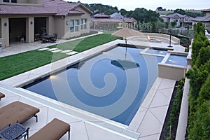 A pool with a waterfall in a luxury backyard