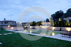 A pool with a waterfall in a luxury backyard